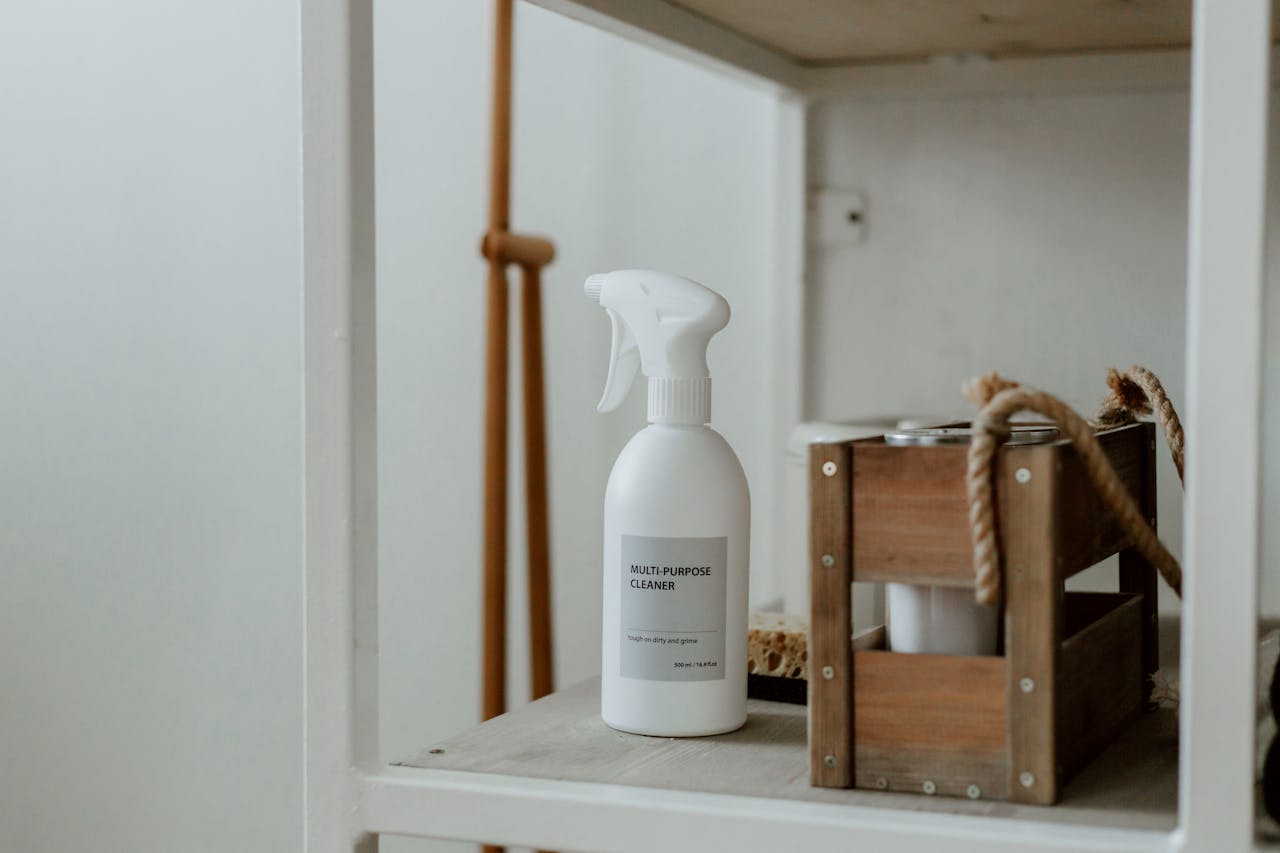 Clean white shelf with a spray cleaner and wooden caddy, perfect for home organization.